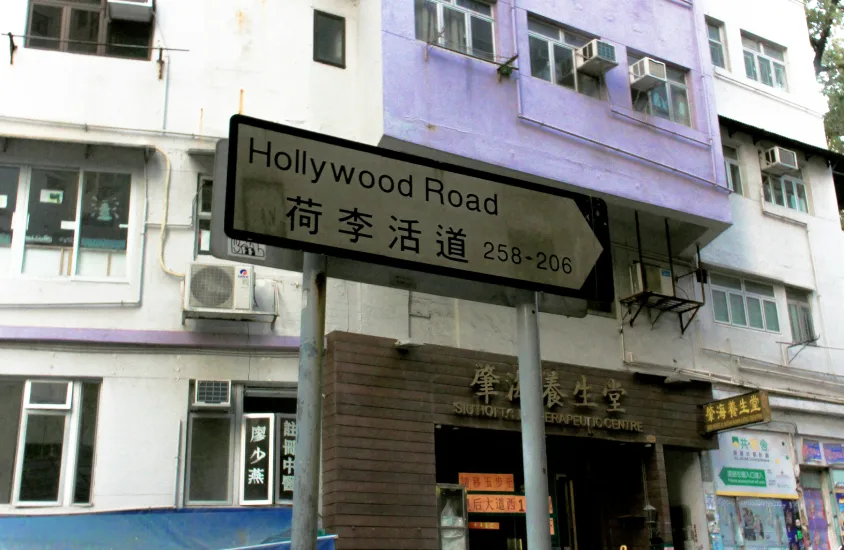 Placa de rua indicando a Hollywood Road, em frente a um prédio antigo em Hong Kon