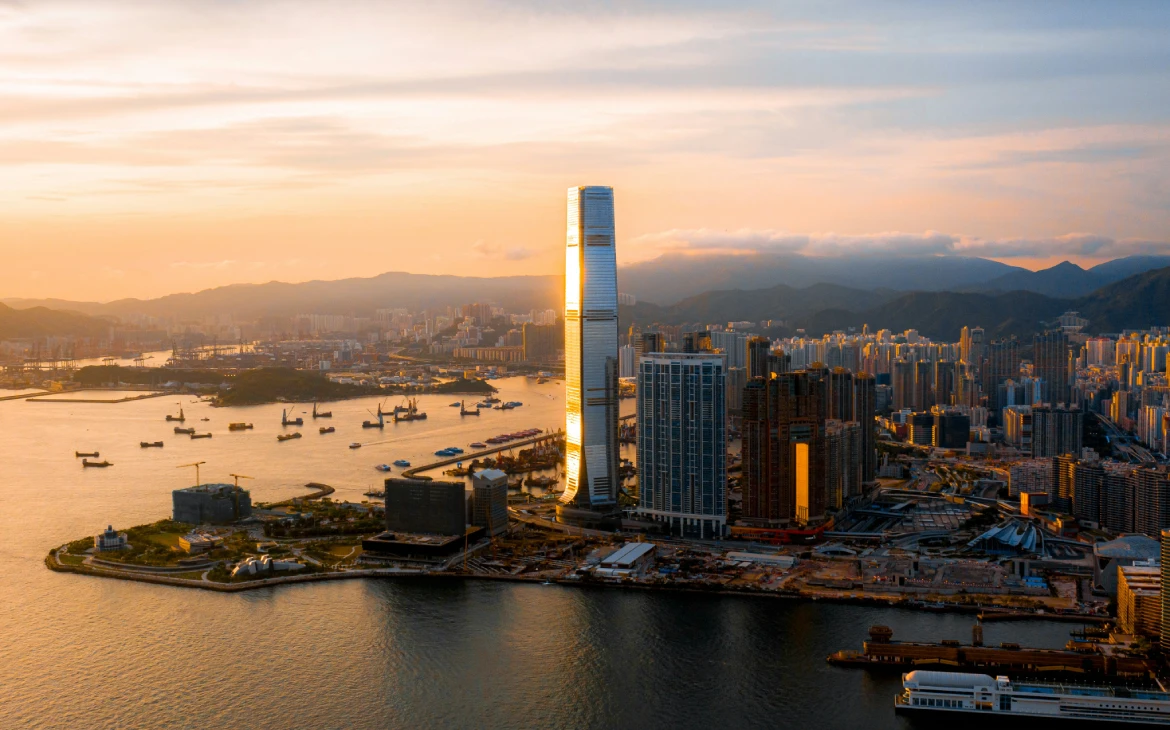 Vista aérea de Hong Kong ao entardecer com arranha-céus e baía ao fundo