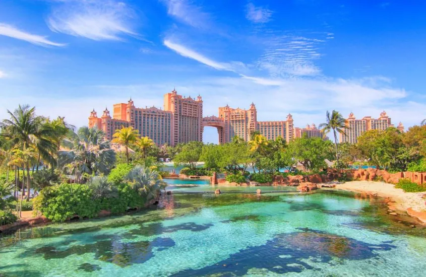 Grande resort no Caribe com diversas piscinas e lagos, cercado por vegetação tropical e edifícios ao fundo