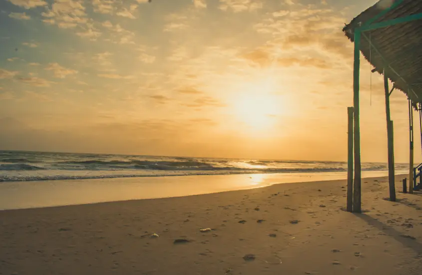 Pôr do sol deslumbrante com o sol se pondo no horizonte do mar, iluminando o céu com tons de laranja e dourado