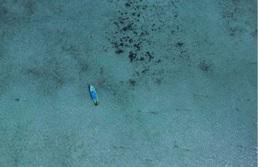 Vista aérea de caiaque flutuando nas águas azul-turquesa de Koh Phi Phi durante o dia