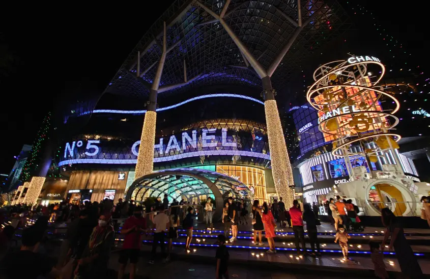 Fachada iluminada do shopping ION Orchard na Orchard Road, Singapura, à noite.