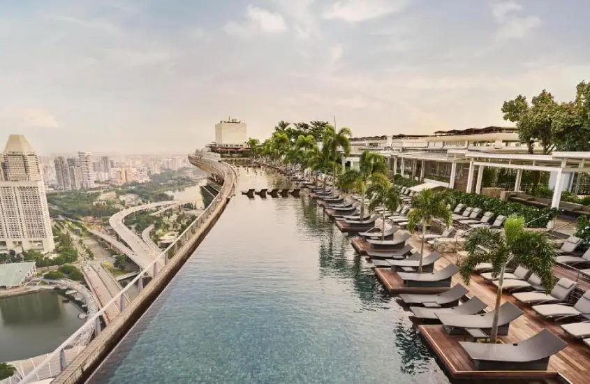 Piscina de borda infinita no topo do Marina Bay Sands com vista da cidade durante o dia.