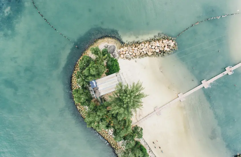 Vista aérea de uma praia na ilha de Sentosa, Singapura, durante o dia.