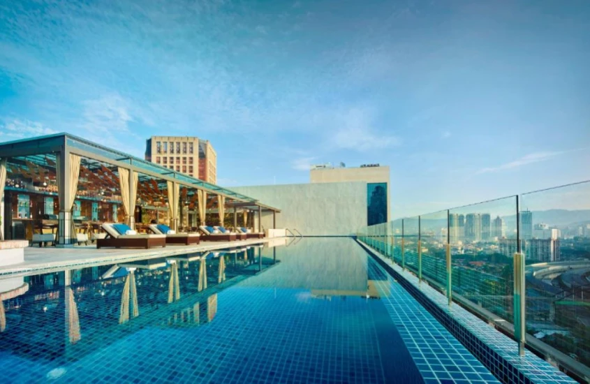 Piscina na cobertura de hotel em Kuala Lumpur com espreguiçadeiras e vista panorâmica