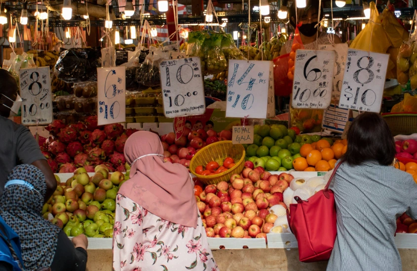 Mercado local em Kuala Lumpur com frutas frescas expostas e preços em placas