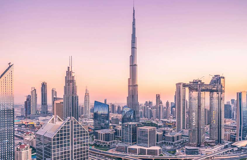 O horizonte de Dubai, com seus edifícios icônicos, incluindo o Burj Khalifa, iluminado pelo pôr do sol.