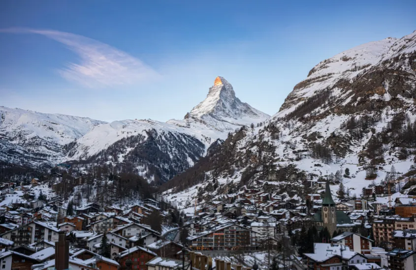 Vista panorâmica de Zermatt, com o icônico Matterhorn ao fundo e chalés cobertos de neve, um dos destinos de inverno mais impressionantes do mundo