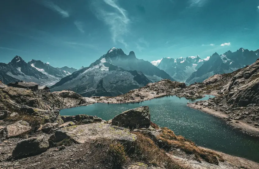 Picos nevados e um lago sereno, com uma cabana ao lado das montanhas em Chamonix, um dos destinos de inverno mais incríveis da Europa