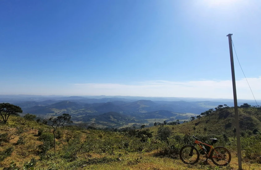 Uma bicicleta solitária repousa na colina sob o sol da tarde em Betim, cidade próxima a Inhotim, onde a tranquilidade das montanhas se mistura ao verde das colinas