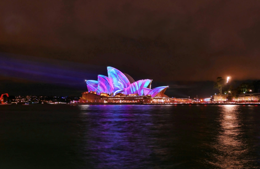 O Sydney Opera House iluminado à noite durante o festival de luzes Vivid Sydney, um evento cultural famoso na Austrália