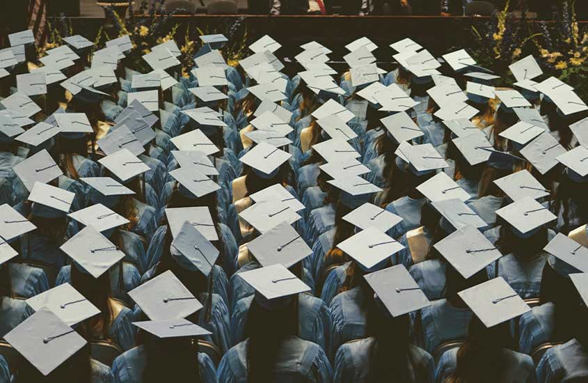 Formatura com vários alunos usando becas