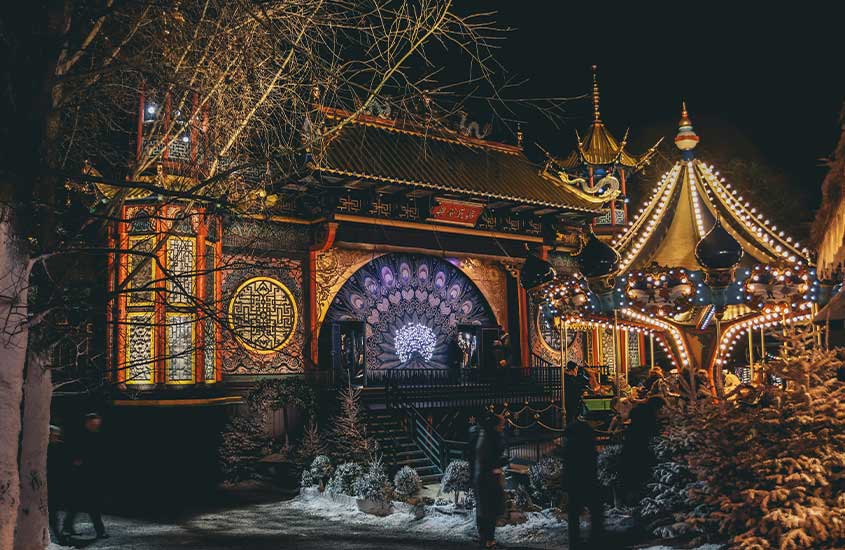 Cenário noturno do Tivoli Gardens em Copenhague, Dinamarca, iluminado por luzes festivas