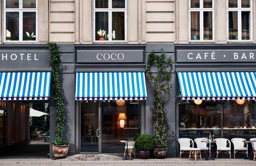 Fachada de um hotel boutique com toldos listrados em Copenhague