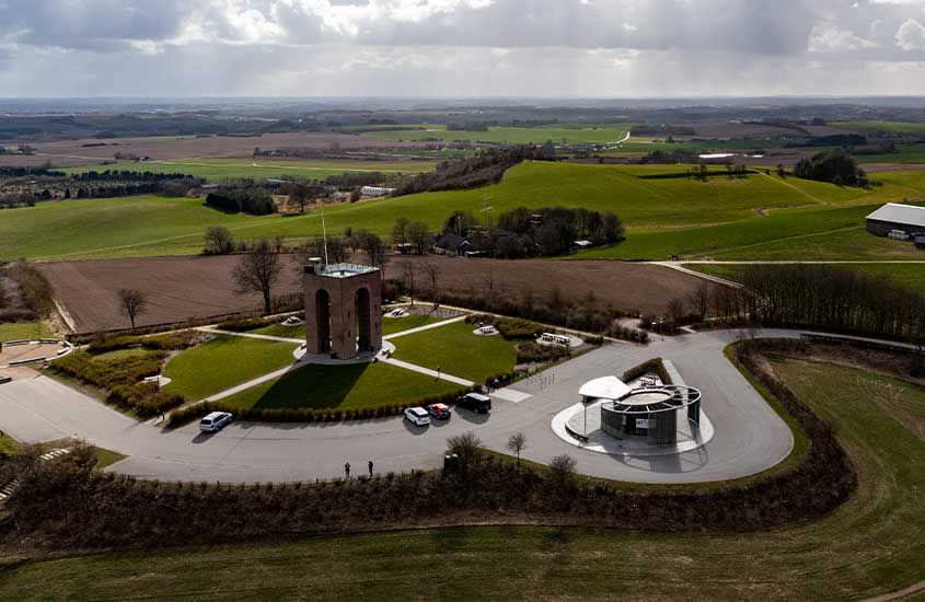 Vista aérea da Torre de Skamlingsbanken, cercada por campos verdes