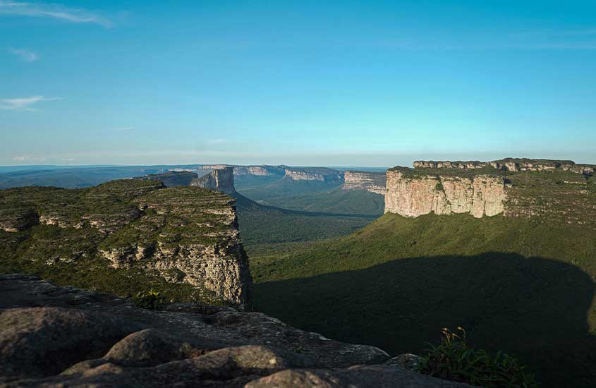 Vista das formações rochosas da Chapada Diamantina, com cânions e vales se estendendo no horizonte sob o céu azul