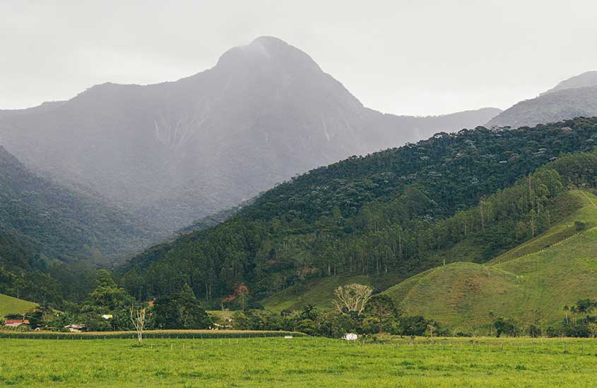 Serra do Caparaó ao amanhecer, com montanhas verdes e céu nublado