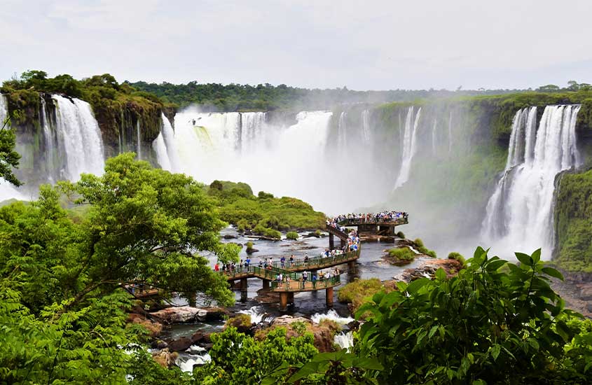 Cataratas do Iguaçu com turistas caminhando pelas passarelas e vegetação densa ao redor