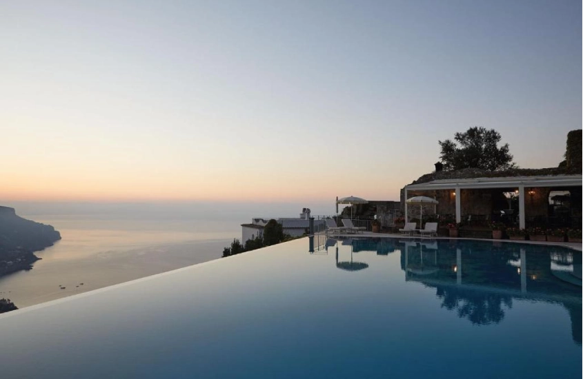 Piscina de borda infinita no Caruso, com vista para o pôr do sol sobre o mar na Costa Amalfitana