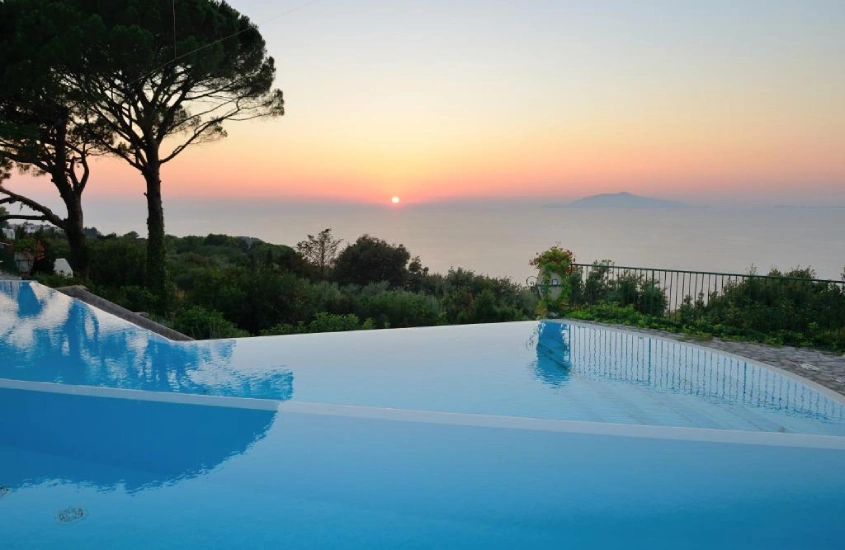 Piscina de borda infinita com vista para o pôr do sol no mar Mediterrâneo no Hotel Caesar Augustus em Capri