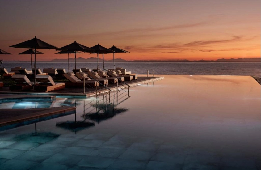 Piscina de borda infinita com espreguiçadeiras ao entardecer no Lesante Blu, com vista para o mar em Zakynthos