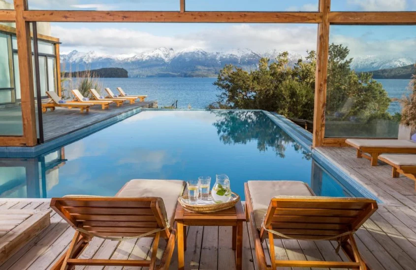 Piscina com borda infinita, vista para o lago e montanhas nevadas, no Correntoso Lake & River Hotel, um dos melhores resorts de inverno na Argentina