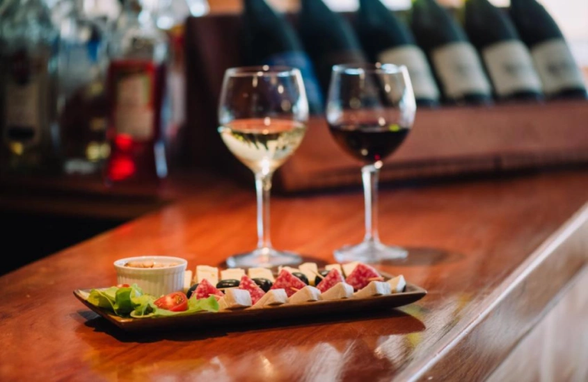 Tábuas de queijos e vinhos servidos no bar do Hotel Chalet Valluga, combinando conforto com a tranquilidade