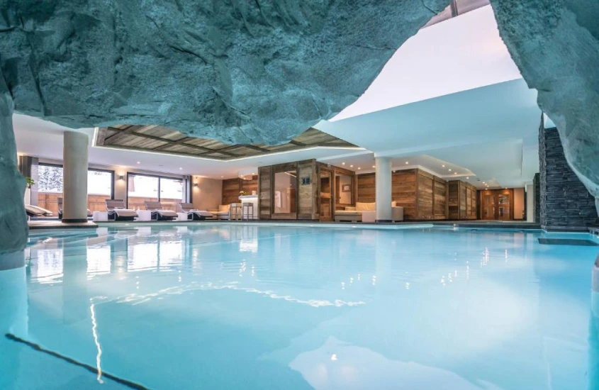 Piscina interna luxuosa em estilo cavernoso com design de rocha natural no hotel Le Kaïla