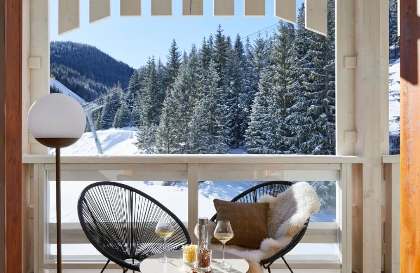 Varanda com vista para pistas de esqui e floresta de pinheiros no Ecrin Blanc Resort, resort de inverno na França