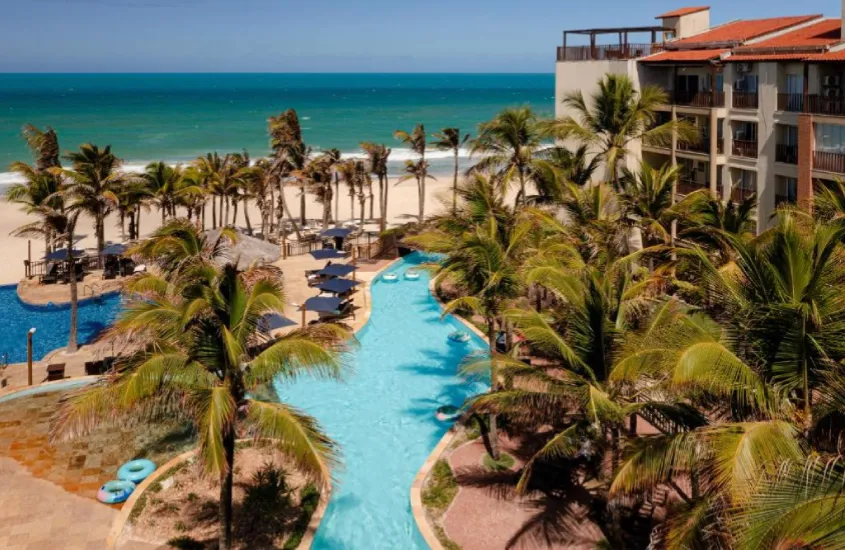 Piscina ao ar livre com vista para a praia no Beach Park Resort, Aquiraz, Ceará, em um dia ensolarado