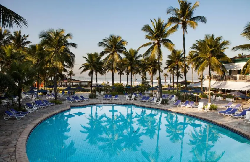 Piscina rodeada de coqueiros com vista para o mar no Casa Grande Hotel Resort & Spa.