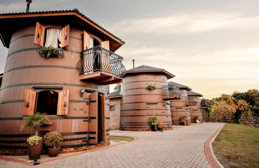 Estruturas em forma de barril gigantes transformadas em acomodações, em um hotel temático de vinhos, com janelas e varandas.