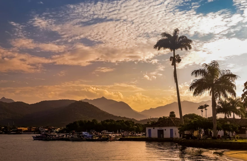 Pôr do sol sobre o mar em Paraty, Brasil, com montanhas ao fundo