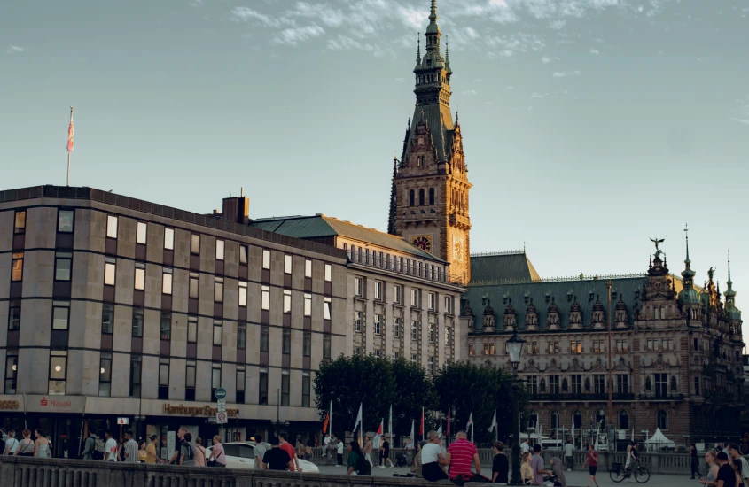 Vista da praça com a Prefeitura de Hamburgo em destaque, ao entardecer.