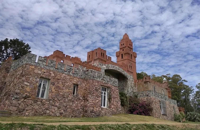 Fachada de pedra do Castillo Pittamiglio, uma construção enigmática com traços de alquimia, situada à beira da Rambla de Montevidéu