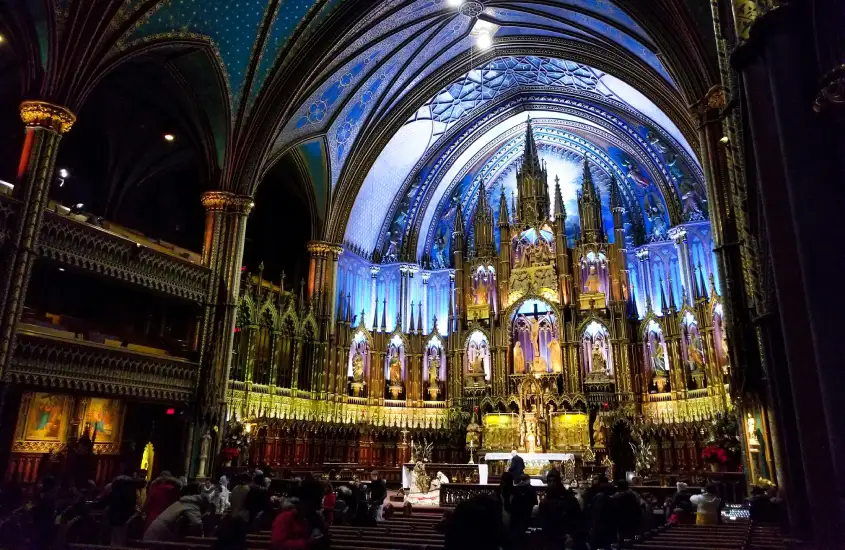 Interior detalhado da Basílica de Notre-Dame, com sua arquitetura gótica e vitrais iluminados, um dos principais pontos turísticos de Montreal