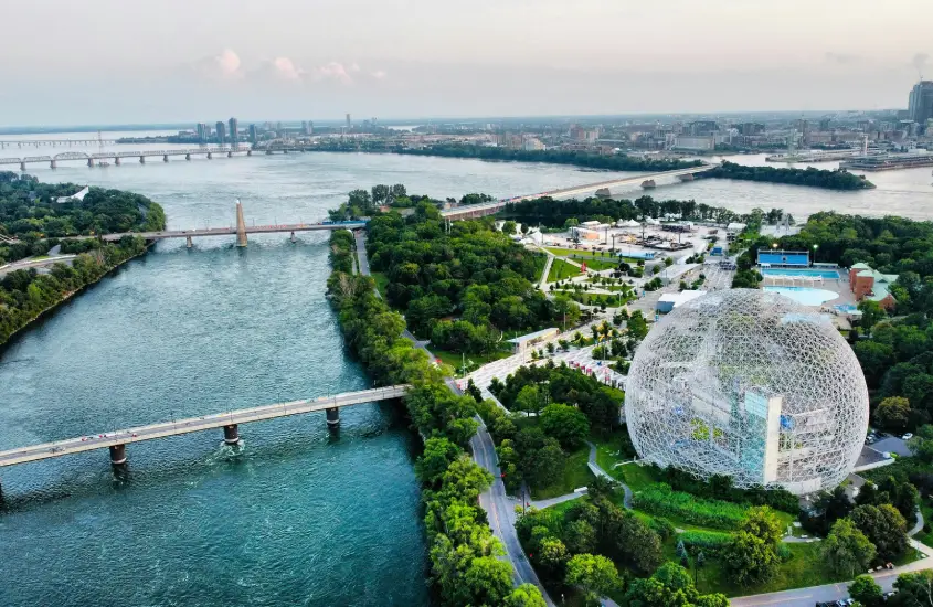 Vista aérea da icônica Biosfera de Montreal, uma estrutura geodésica impressionante cercada por áreas verdes e o Rio Saint-Laurent