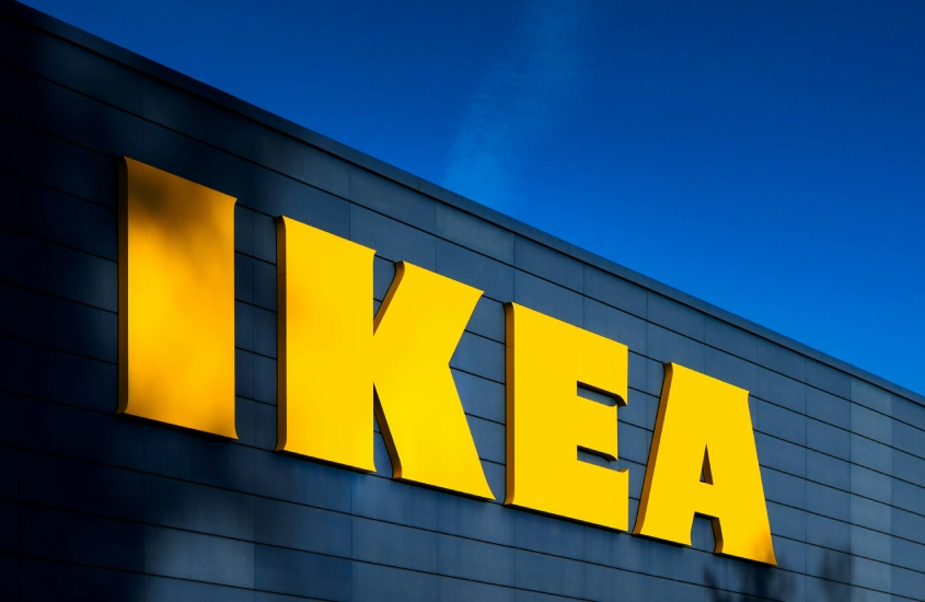 Fachada de uma loja da IKEA com o logo amarelo destacado contra um céu azul.