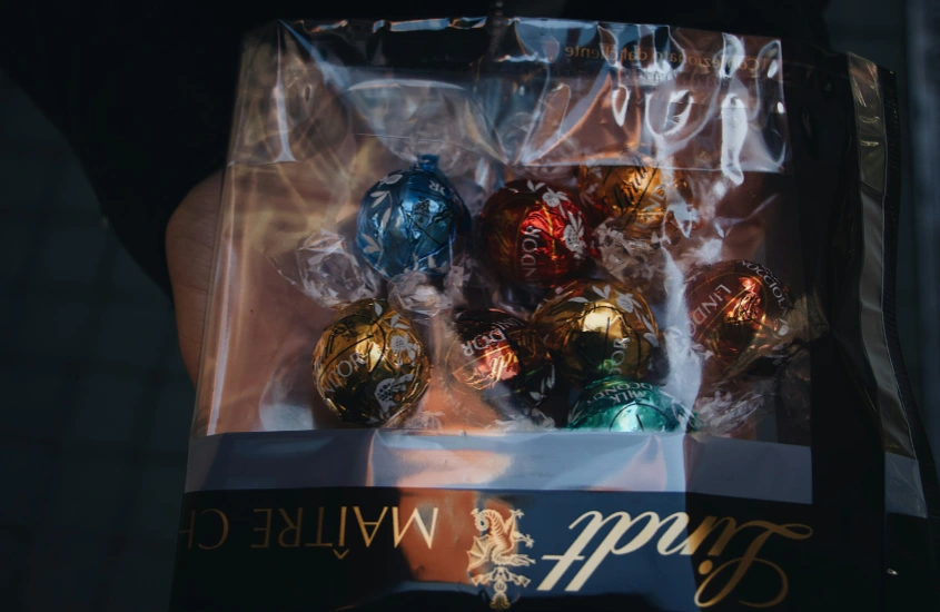 Pacote de chocolates Lindt coloridos em uma embalagem de plástico transparente