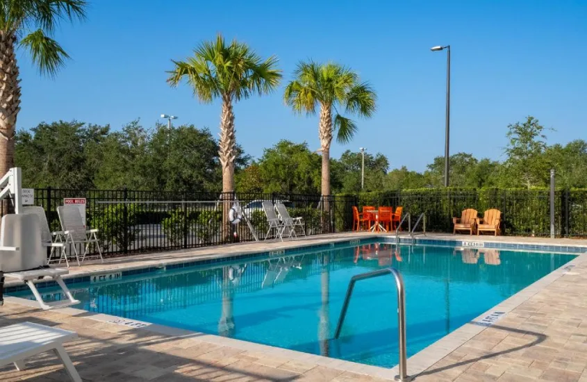 Piscina ao ar livre cercada por palmeiras no SPOT X Hotel Orlando na International Drive