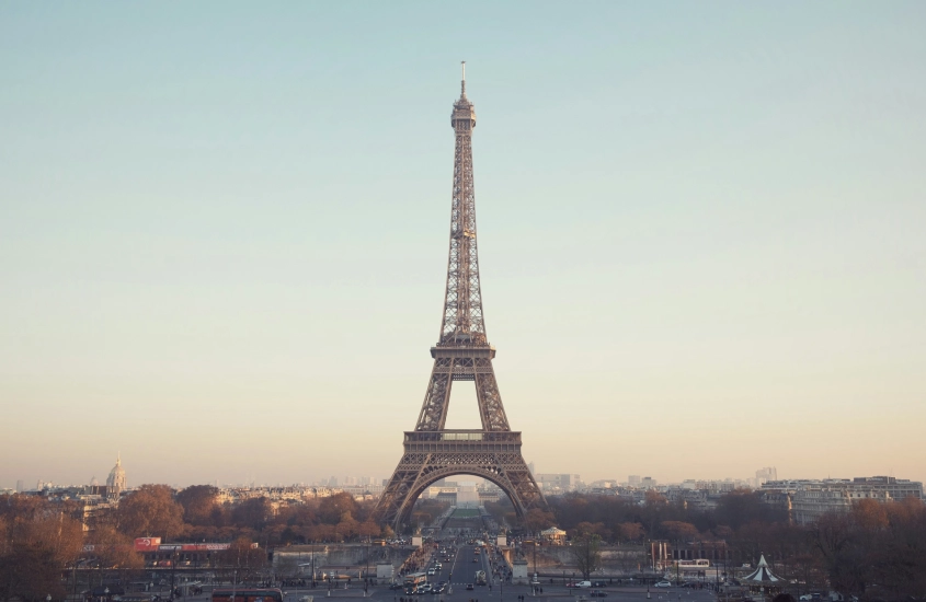 Torre Eiffel ao amanhecer, com o céu claro ao fundo e Paris ao redor, vista a partir da Praça do Trocadéro