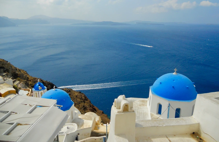 Vista aérea de cúpulas azuis e o mar em Santorini