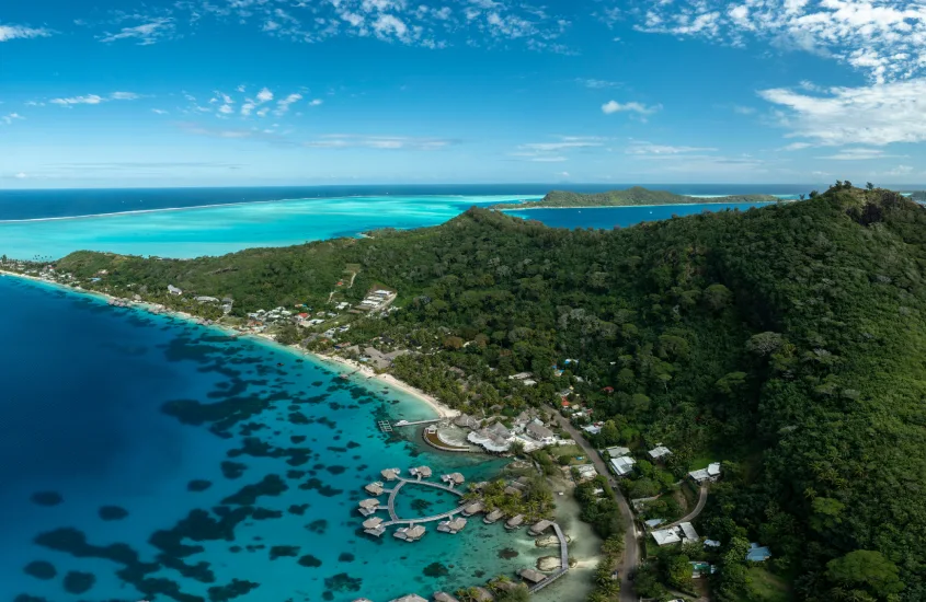 Vista aérea de uma lagoa em um dos destinos mais românticos do mundo, rodeada por montanhas exuberantes e águas cristalinas