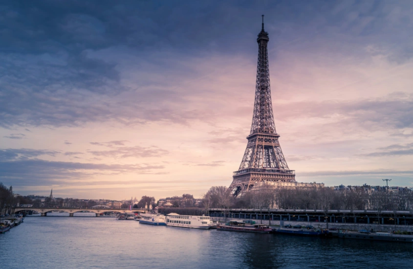 A Torre Eiffel iluminada ao entardecer, refletindo a magia de Paris, um dos melhores destinos de lua de mel