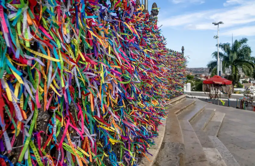 Mural de fitinhas do Bonfim em Salvador, com cores vibrantes e mensagens de fé, símbolo icônico da cultura baiana.