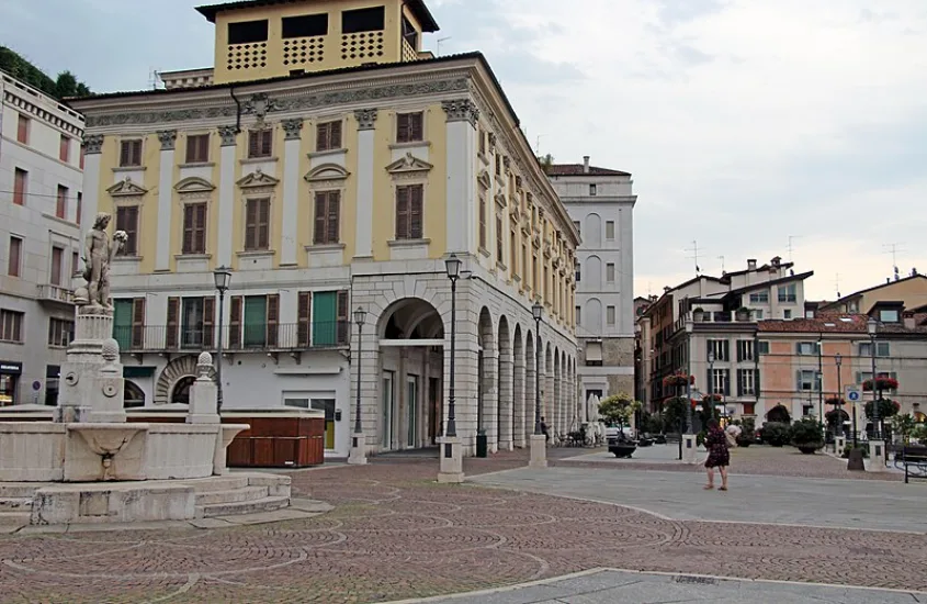 Praça em Nápoles com fontes e edifícios históricos ao redor, destacando o charme arquitetônico da cidade.