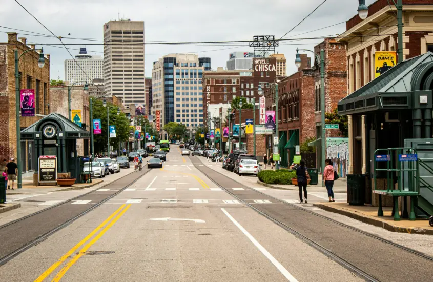 Rua movimentada de South Main em Memphis, mostrando prédios históricos, bondes e a atmosfera urbana do bairro.