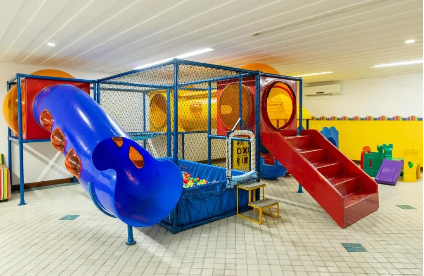 Playground infantil de um hotel com piscina de bolinhas e brinquedos ao redor