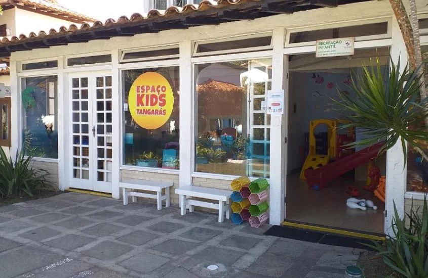 Porta do playgroundde um hotel onde ficar com crianças em Búzios e plantas decorativas ao redor