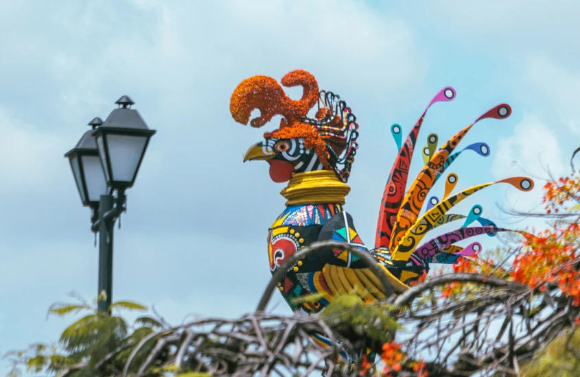 Escultura colorida de um galo gigante, representando o símbolo do Carnaval de Recife, com detalhes vibrantes e decoração artística.